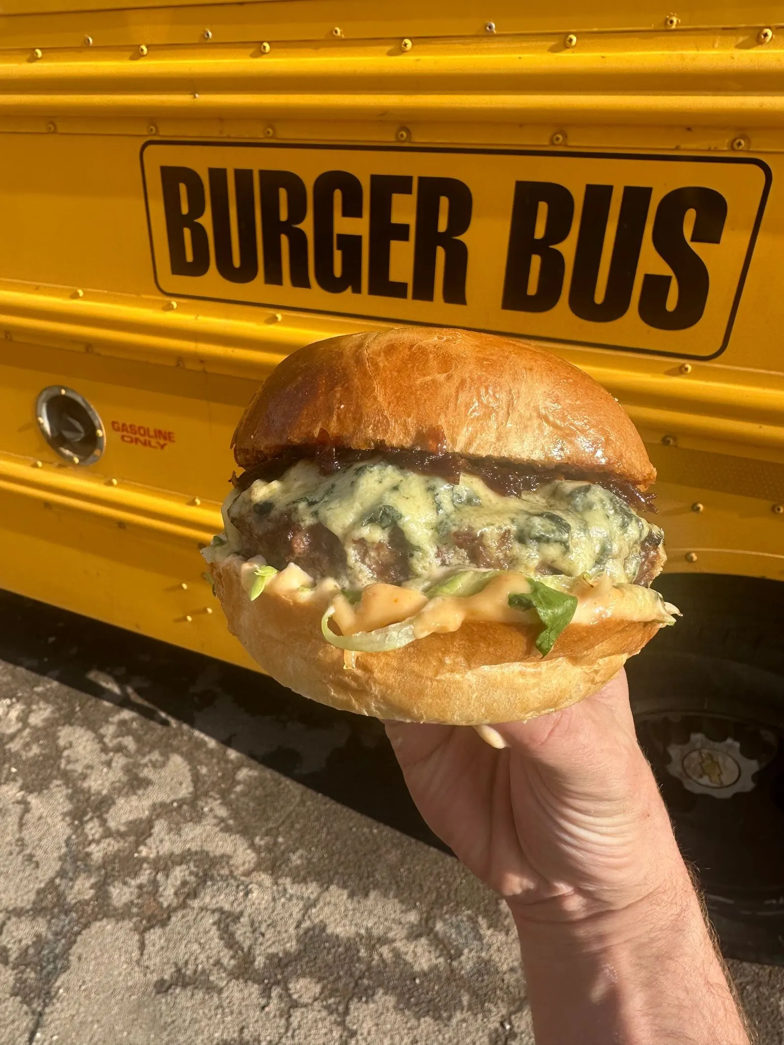 Beef and blue burger in front of the bus stop sign