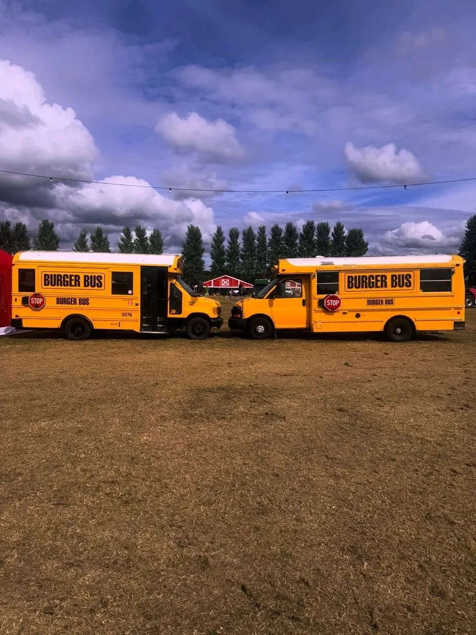 Two Burger Bus vehicles in an event field